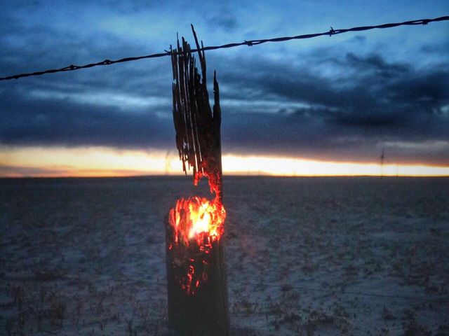 The charred remains of a wooden fencepost continue to burn after wildfires swept through northeastern Colorado on Tuesday. Wildfires across the entire High Plains region destroyed homes, farm buildings, fences, crops and livestock, and also resulted in the loss of human lives. (Photo courtesy of Ryan Kanode Haxtun, Colorado)